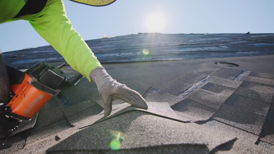 Roofer using a nail gun to affix shingles to a roof